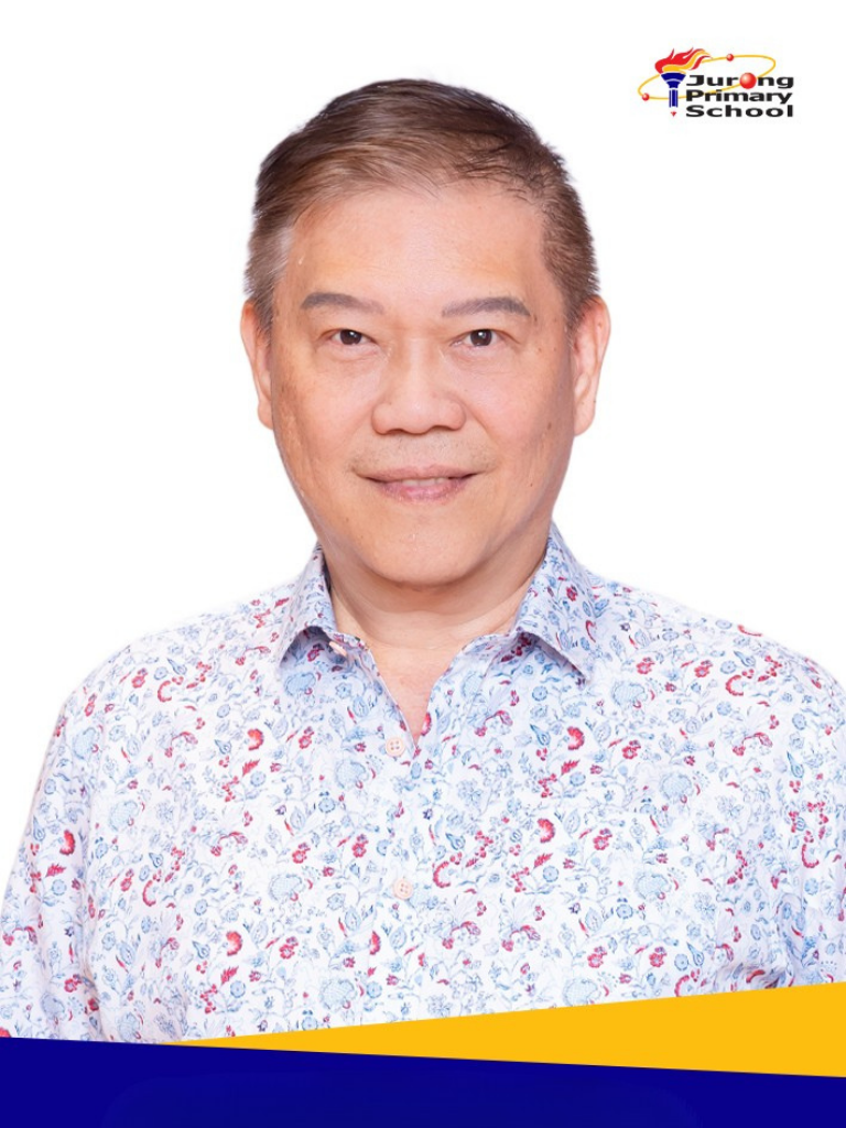Smiling man in white floral shirt, short grey-brown hair.